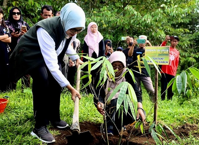 Bupati Blitar, Hj. Rini Syarifah menanam pohon dalam kegiatan Tanam Bambu dan Ngaji Tani di Sumber Talang Abang Desa Karangrejo Kecamatan Garum Kecamatan Garum. (dok. Kominfo Kab Blitar)