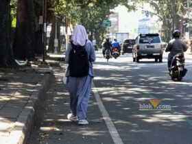 Salah seorang pejalan kaki di bahu jalan raya (Satria Akbar Sigit/Blok-a.com)