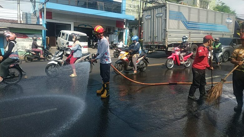 Caption: Petugas Damkar Kota Malang lakukan pembersihan jalan pasca tumpahan solar, Jumat (5/7/2024) (blok-a/Andik Agus)