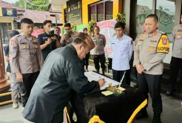 FOTO : Ketua PSHT Cabang Kabupaten Blitar Tugas Naggolo Dili Prasetiono menandatangani akrar damai di Mapolres Blitar Kota. (Foto : blok-a.com/Fajar)