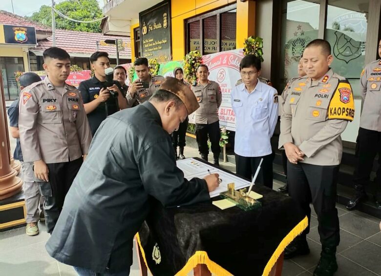 FOTO : Ketua PSHT Cabang Kabupaten Blitar Tugas Naggolo Dili Prasetiono menandatangani akrar damai di Mapolres Blitar Kota. (Foto : blok-a.com/Fajar)