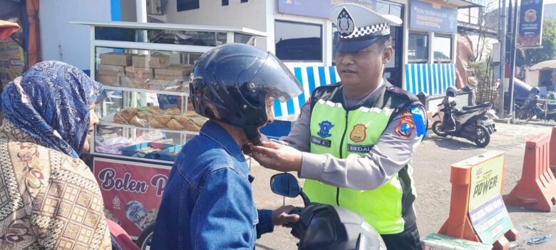 Petugas kepolisian melakukan tindakan preventif dengan memasangkan helm bagi pengguna jalan (dok. Humas Polres Malang for blok-a.com)