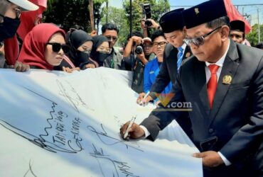 Anggota DPRD Kota Blitar menandatangani kain putih simbol komitmen untuk selalu mendengarkan aspirasi rakyat dan menjaga integritas. (blok-a.com/Fajar)