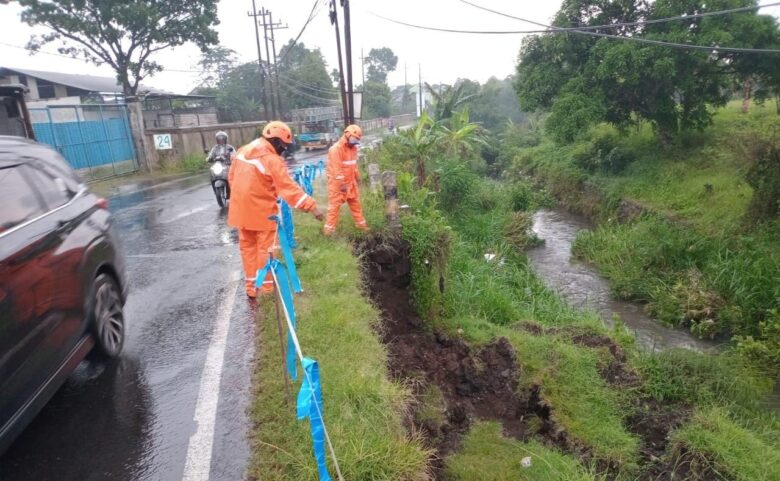 Petugas memasang garis pengaman di jalan alternatif penghubung Lawang-Singosari-Jabung yang mengalami longsor (BPBDKabMalang)