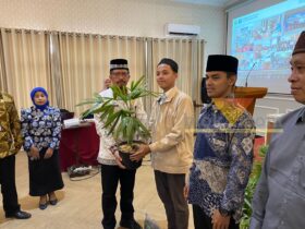 Plh Kepala DLH Kota Malang, Gamaliel Raymond Hatigoran, menyerahkan bibit tanaman secara simbolis kepada peserta kegiatan Deseminasi Program Eco Pesantren di Hotel Pelangi, Kamis (30/10/2025). (blok-a/Bob Bimantara Leander)