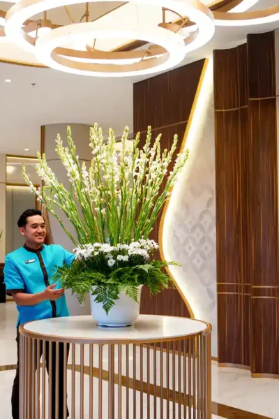 Staf Atria Hotel Malang menyempurnakan rangkaian bunga segar yang menyambut para tamu di lobi (foto: ist)