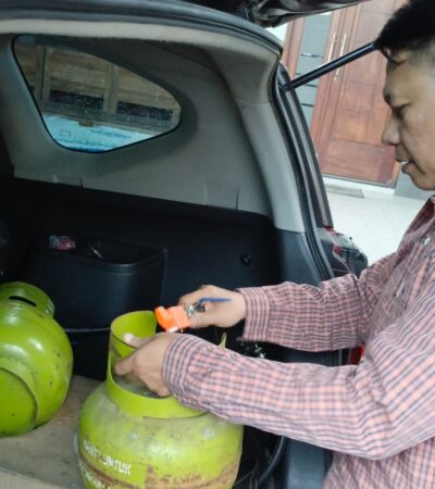 Teks: Pak Yoko driver online Mojokerto saat mempraktekkan pemasangan gas LPG pada kendaraannya.(blok-a.com/Syahrul Wijaya)