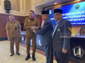 Bahas MoU Baru, Pemkot Malang Gandeng Unisma Tangani Banjir hingga Kemacetan Kota Malang, blok-a.com – Pemerintah Kota Malang membahas perpanjangan kerja sama dengan Universitas Islam Malang (Unisma) dalam audiensi yang digelar di Balai Kota Malang, Senin (25/5/2026). Kerja sama tersebut diarahkan untuk mendukung penyelesaian berbagai persoalan perkotaan hingga penguatan program strategis daerah. Wali Kota Malang Wahyu Hidayat mengatakan, selama ini Pemkot Malang telah memiliki nota kesepahaman (MoU) dengan Unisma. Namun, masa kerja sama itu kini hampir berakhir sehingga perlu dilakukan evaluasi sekaligus pembaruan. “Iya, audiensi untuk kerja sama. Selama ini kita sudah ada MoU dengan Unisma, dan ini hampir habis. Nah, kita evaluasi terkait dengan apa yang dapat kita kerja samakan kembali antara Pemerintah Kota Malang dengan Unisma,” ujar Wahyu Hidayat. Menurutnya, perguruan tinggi memiliki peran penting dalam membantu pemerintah menyelesaikan persoalan perkotaan di Kota Malang. Karena itu, Pemkot Malang ingin melibatkan akademisi dan mahasiswa dalam berbagai program pembangunan. “Beberapa permasalahan-permasalahan perkotaan yang ada di Kota Malang juga kami sampaikan. Nanti kita akan melibatkan dari perguruan tinggi untuk bisa membantu menyelesaikan permasalahan-permasalahan tersebut,” katanya. Wahyu menyebut sejumlah isu yang menjadi perhatian dalam kerja sama itu antara lain kemacetan, banjir, pengendalian inflasi hingga dukungan terhadap program strategis nasional di Kota Malang. “Banjir, kemudian juga terkait bagaimana menyelesaikan inflasi. Kemudian juga terkait ada kebijakan program strategis nasional yang ada di Kota Malang ini. Nah, ini kita kerja samakan,” ungkapnya. Selain itu, Pemkot Malang juga mendorong kontribusi mahasiswa terhadap lingkungan tempat tinggal mereka, termasuk melalui program Kuliah Kerja Nyata (KKN) di kawasan permukiman mahasiswa dan rumah kos. Sementara itu, Rektor Universitas Islam Malang Prof. Drs. H. Junaidi, M.Pd., Ph.D. menyambut baik rencana perpanjangan kerja sama tersebut. Ia mengatakan, MoU yang diperbarui nantinya akan menjadi dasar bagi organisasi perangkat daerah (OPD) dan fakultas di Unisma untuk menjalankan program teknis bersama. “MoU kita sudah mau habis, sehingga akan kita renew, perbaharui. Sehingga nanti MoU itu menjadi cantolan untuk OPD-OPD secara teknis mengimplementasikan bersama dengan fakultas atau dengan Lembaga Penelitian dan Pengabdian kepada Masyarakat,” kata Junaidi. Ia juga mendukung gagasan pelibatan mahasiswa agar lebih berkontribusi di lingkungan tempat tinggalnya selama menempuh pendidikan di Kota Malang. “Keberadaan mahasiswa itu tidak hanya numpang tempat tinggal, tetapi memang bisa berkontribusi sesuatu kepada di mana mereka tinggal itu,” ujarnya. Selain mendukung tata kelola perkotaan, Unisma juga siap membantu program sertifikasi halal UMKM di Kota Malang melalui Lembaga Pemeriksa Halal (LPH) yang dimiliki kampus tersebut. “Kami punya Lembaga Pemeriksa Halal. Sehingga nanti bisa kami optimalkan untuk mendukung percepatan sertifikasi halal UMKM di Kota Malang,” tuturnya.