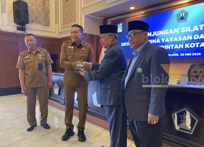 Bahas MoU Baru, Pemkot Malang Gandeng Unisma Tangani Banjir hingga Kemacetan Kota Malang, blok-a.com – Pemerintah Kota Malang membahas perpanjangan kerja sama dengan Universitas Islam Malang (Unisma) dalam audiensi yang digelar di Balai Kota Malang, Senin (25/5/2026). Kerja sama tersebut diarahkan untuk mendukung penyelesaian berbagai persoalan perkotaan hingga penguatan program strategis daerah. Wali Kota Malang Wahyu Hidayat mengatakan, selama ini Pemkot Malang telah memiliki nota kesepahaman (MoU) dengan Unisma. Namun, masa kerja sama itu kini hampir berakhir sehingga perlu dilakukan evaluasi sekaligus pembaruan. “Iya, audiensi untuk kerja sama. Selama ini kita sudah ada MoU dengan Unisma, dan ini hampir habis. Nah, kita evaluasi terkait dengan apa yang dapat kita kerja samakan kembali antara Pemerintah Kota Malang dengan Unisma,” ujar Wahyu Hidayat. Menurutnya, perguruan tinggi memiliki peran penting dalam membantu pemerintah menyelesaikan persoalan perkotaan di Kota Malang. Karena itu, Pemkot Malang ingin melibatkan akademisi dan mahasiswa dalam berbagai program pembangunan. “Beberapa permasalahan-permasalahan perkotaan yang ada di Kota Malang juga kami sampaikan. Nanti kita akan melibatkan dari perguruan tinggi untuk bisa membantu menyelesaikan permasalahan-permasalahan tersebut,” katanya. Wahyu menyebut sejumlah isu yang menjadi perhatian dalam kerja sama itu antara lain kemacetan, banjir, pengendalian inflasi hingga dukungan terhadap program strategis nasional di Kota Malang. “Banjir, kemudian juga terkait bagaimana menyelesaikan inflasi. Kemudian juga terkait ada kebijakan program strategis nasional yang ada di Kota Malang ini. Nah, ini kita kerja samakan,” ungkapnya. Selain itu, Pemkot Malang juga mendorong kontribusi mahasiswa terhadap lingkungan tempat tinggal mereka, termasuk melalui program Kuliah Kerja Nyata (KKN) di kawasan permukiman mahasiswa dan rumah kos. Sementara itu, Rektor Universitas Islam Malang Prof. Drs. H. Junaidi, M.Pd., Ph.D. menyambut baik rencana perpanjangan kerja sama tersebut. Ia mengatakan, MoU yang diperbarui nantinya akan menjadi dasar bagi organisasi perangkat daerah (OPD) dan fakultas di Unisma untuk menjalankan program teknis bersama. “MoU kita sudah mau habis, sehingga akan kita renew, perbaharui. Sehingga nanti MoU itu menjadi cantolan untuk OPD-OPD secara teknis mengimplementasikan bersama dengan fakultas atau dengan Lembaga Penelitian dan Pengabdian kepada Masyarakat,” kata Junaidi. Ia juga mendukung gagasan pelibatan mahasiswa agar lebih berkontribusi di lingkungan tempat tinggalnya selama menempuh pendidikan di Kota Malang. “Keberadaan mahasiswa itu tidak hanya numpang tempat tinggal, tetapi memang bisa berkontribusi sesuatu kepada di mana mereka tinggal itu,” ujarnya. Selain mendukung tata kelola perkotaan, Unisma juga siap membantu program sertifikasi halal UMKM di Kota Malang melalui Lembaga Pemeriksa Halal (LPH) yang dimiliki kampus tersebut. “Kami punya Lembaga Pemeriksa Halal. Sehingga nanti bisa kami optimalkan untuk mendukung percepatan sertifikasi halal UMKM di Kota Malang,” tuturnya.