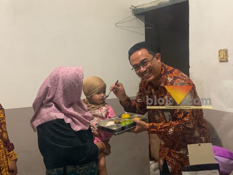 Kepala Perwakilan Kemendukbangga/BKKBN Provinsi Jawa Timur, Shodiqin saat menyuapi putri dari penerima manfaat, Siti Badriah (blok-a.com / Yogga Ardiawan)